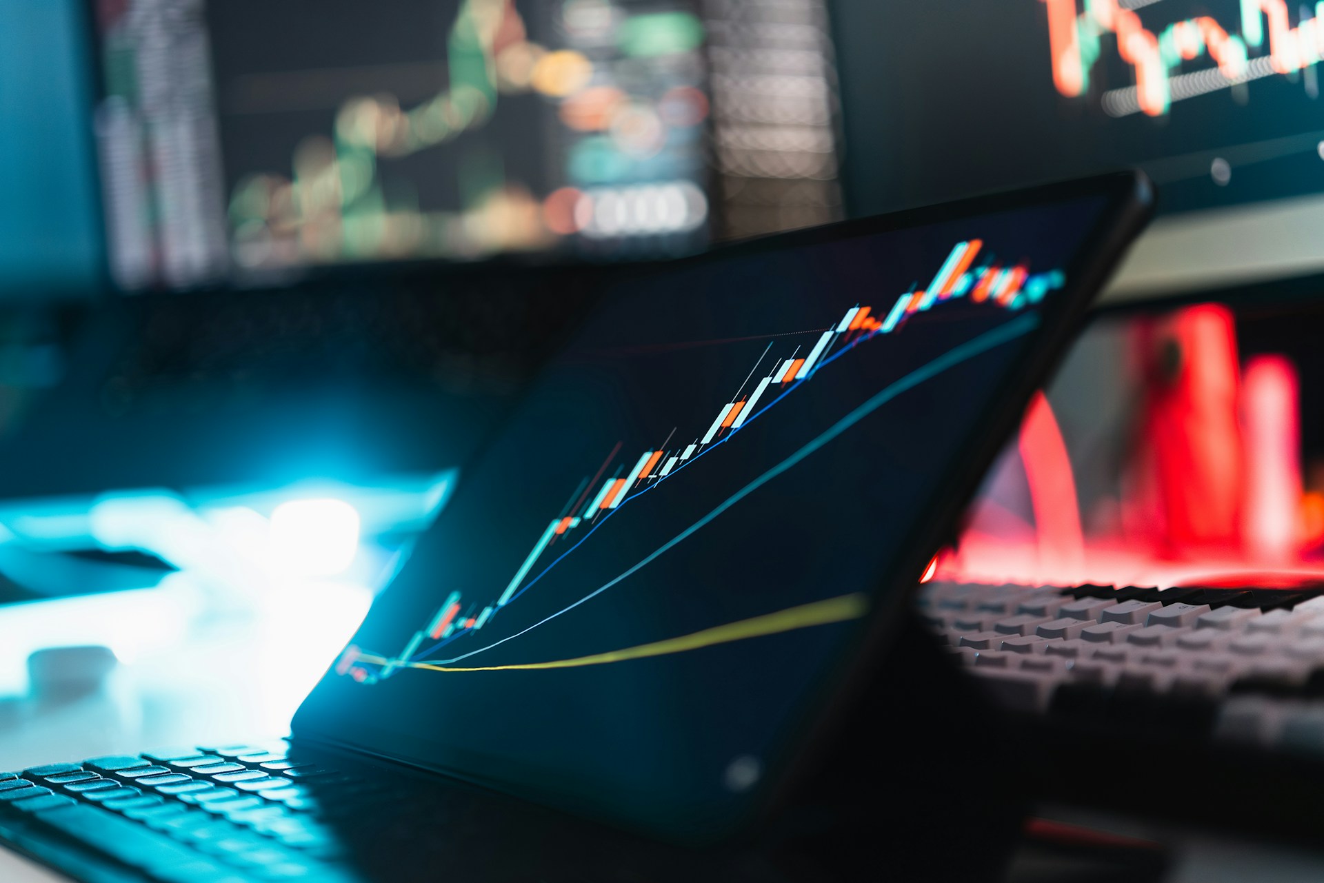 A close-up of a tablet displaying a rising stock chart, with other financial data screens in the background, symbolizing the growth potential when investing in frontier markets.